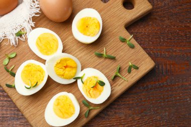 Haşlanmış yumurtaların yarısı ve ahşap masanın üstünde mikroyeşiller.