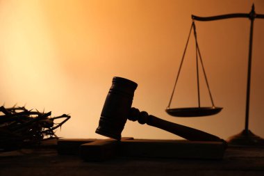 Hakimin tokmağı, dikenli taç ve ahşap masa üzerinde soluk turuncu eğimli arka plan, yakın çekim