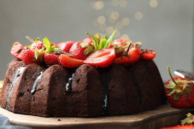 Çilekli ve nane arkaplanlı lezzetli çikolatalı kek, yakın plan.