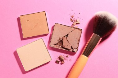 Kozmetik ürünlerinin kaplarını doldur ve pembe arka planda fırçala, düz yat