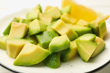 Lezzetli avokado ve limon beyaz masada, yakın plan.