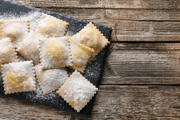 Ahşap masanın üstünde pişmemiş ravioli, üst manzara. Metin için boşluk