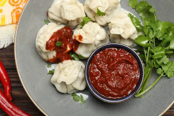 Baharatlı, soslu, ahşap masada kişniş soslu lezzetli hinkali.