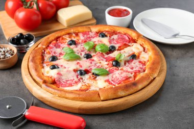 Gri masada lezzetli pizza ve malzemeler, yakın plan.
