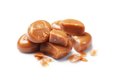 Kırık, lezzetli karamel şekerlemeler beyazda izole edilmiş.