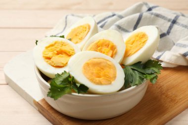 Haşlanmış yumurta ve maydanoz ahşap masada, yakın plan.