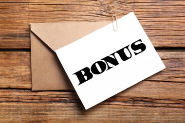 Kâğıt kelime ikramiyesi ve ahşap masa üzerinde zarf, üst görünüm