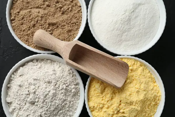 Tabaklardaki farklı un türleri ve masadaki kepçeler, üst görünüm