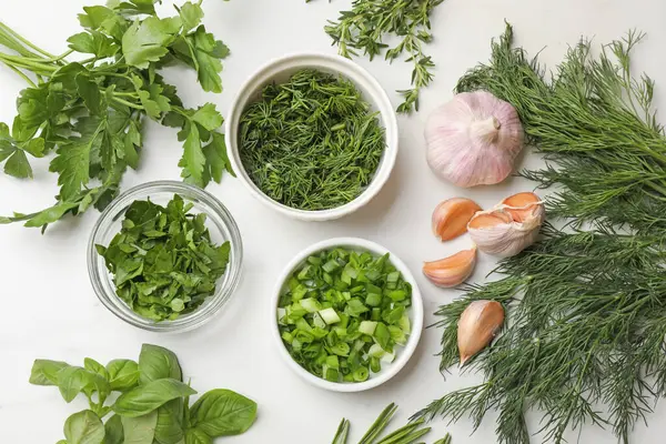 Beyaz masada farklı otlar ve baharatlar var.