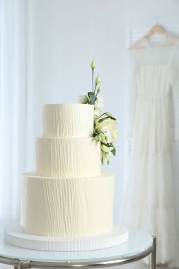 İçerideki masada çiçeklerle süslenmiş nefis düğün pastası.