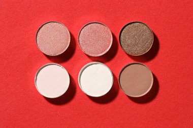 Kırmızı arka planda güzel göz farı dolgu kapları, düz yatış