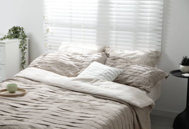 Yatak odasında güzel çarşafları olan rahat bir yatak.