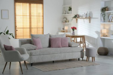 Odada yastıkları olan rahat bir kanepe. İç tasarım