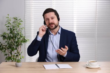 Kulaklıkla hoparlör açık oturulan masada webinar, web kamerasından görüntü