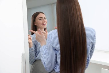 Güzel bir kadın aynada kendine bakıyor.