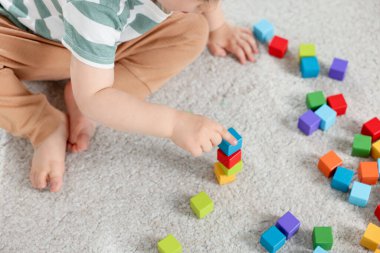 Evde renkli küplerle oynayan sevimli küçük çocuk, yukarıda.