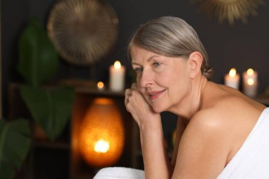 Son sınıf öğrencisi kadın masaj salonundaki masaj koltuğunda dinleniyor, mesaj atmak için yer var.