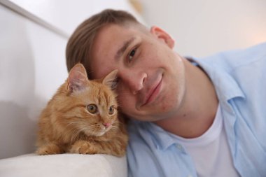 Evde sevimli kızıl kedisi olan bir adam, seçici odaklı.