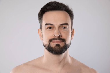 Gri arka planda yakışıklı bir adamın portresi, yakın plan.