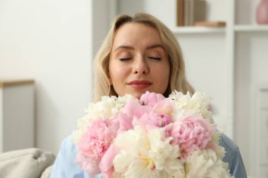 Evinde şakayık demeti olan bir kadın.