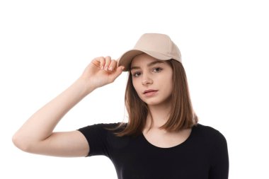 Beyaz arka planda bej renkli şapka takan genç bir kadın.