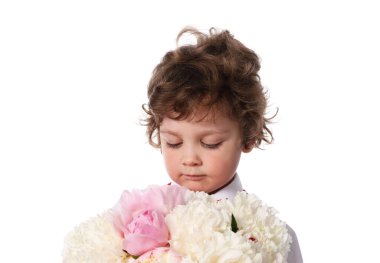 Beyaz arka planda bir buket güzel şakayığı olan sevimli küçük bir çocuk.