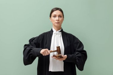 Açık yeşil arkaplanda çekiç ve ses engeli olan yargıç