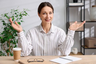 Gülümseyen çevrimiçi hoparlör. İçerideki masada web kamerasından görüntüsü olan webinar.