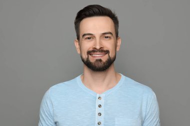 Gri arka planda tıraş olmadan önce gülümseyen adam