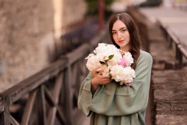 Şehir caddesinde bir buket güzel şakayığı olan çekici bir kadın. Metin için boşluk