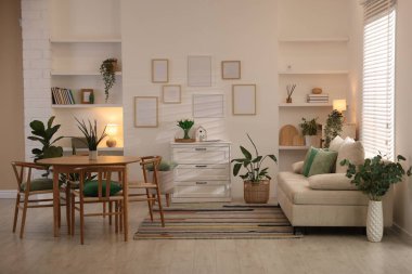 Odada rahat bir kanepe ve sandalyeli şık bir yemek masası. İç tasarım