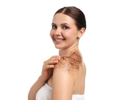 Gülümseyen kadın, beyaz arka planda omzunu ovalıyor.