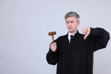 Elinde tokmakla gri arka planda baş parmak gösteren bir yargıç. Metin için boşluk