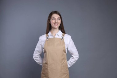 Gri arka planda gülümseyen baristanın portresi