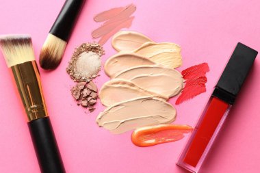 Eflatun arka planda farklı kozmetik ürünler ve makyaj fırçaları, düz yatış