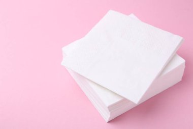 Pembe arka planda beyaz mendil yığını, yakın plan. Metin için boşluk
