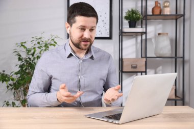 İçerideki masada dizüstü bilgisayarla çevrimiçi hoparlör çalışıyor.