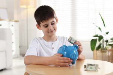 Çocuk içerideki bankaya cep harçlığı yatırıyor.