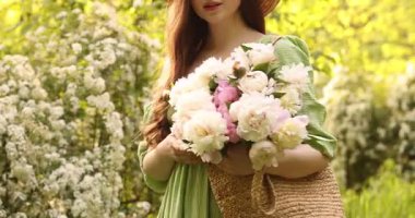 Parkta şakayık demeti olan güzel bir kadın, yakın plan.