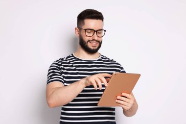 Yakışıklı adam beyaz zemin üzerine tablet kullanma