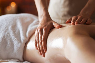 Kaplıcada kadın yağ ile masaj yaptırıyor, yakın plan.