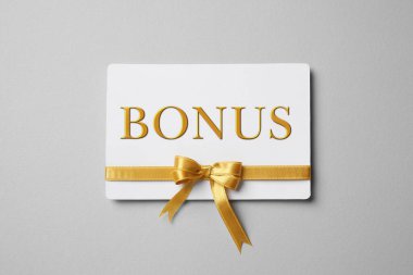 Gri arka planda altın fiyonklu bonus kart, üst manzara