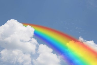 Mavi gökyüzünde parlak gökkuşağı güneşli bir günde bulutlarla