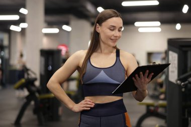 Spor salonunda panosu olan profesyonel kişisel antrenör.