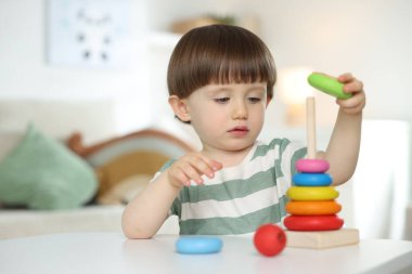 Masada oyuncak piramidiyle oynayan sevimli küçük çocuk.