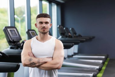 Spor merkezinde profesyonel kişisel antrenör portresi. Metin için boşluk