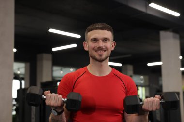 Spor salonunda dambılı olan profesyonel kişisel antrenör.