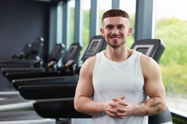 Spor merkezinde profesyonel kişisel antrenör portresi. Metin için boşluk