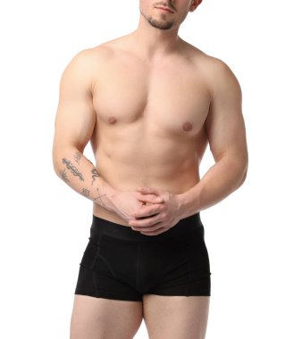 Beyaz arka planda siyah iç çamaşırlı genç adam, yakın plan.