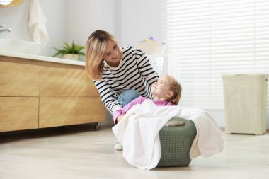 Anne ve kızı evde çamaşır yıkarken eğleniyorlar.